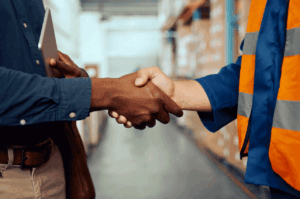 Image displaying a successful distributor management relationship with a close up of a distributor and a manager shaking hands.