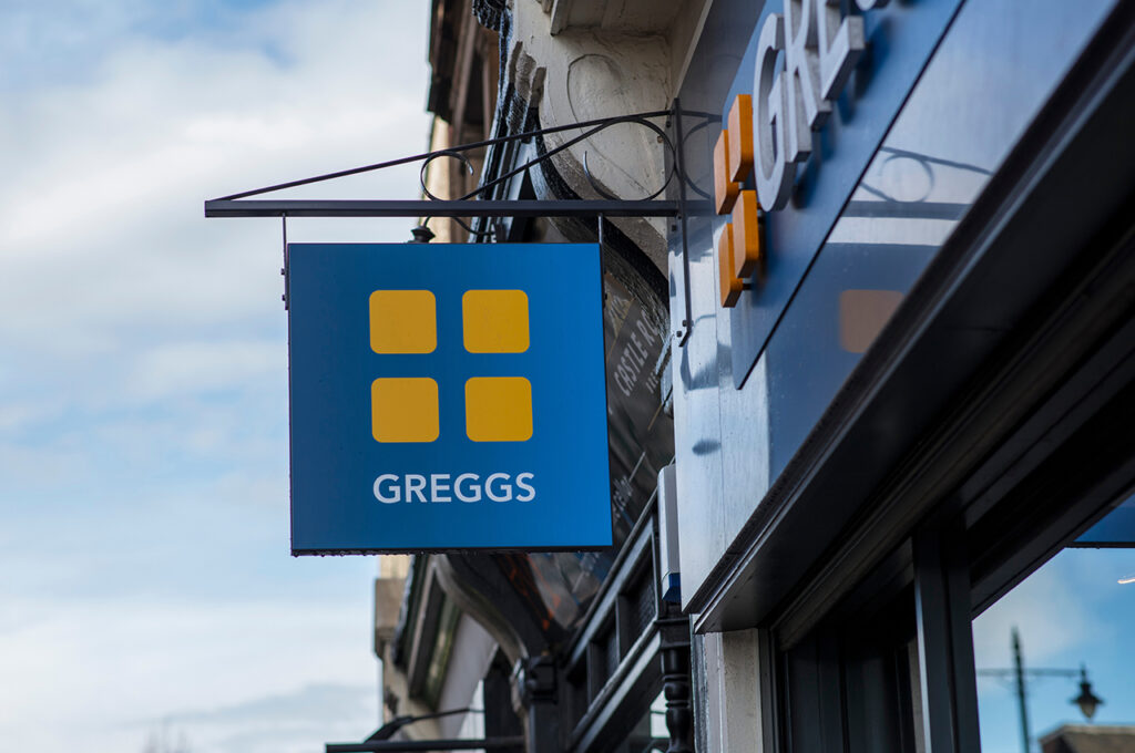 the sign hanging off a Greggs shop on a UK highstreet